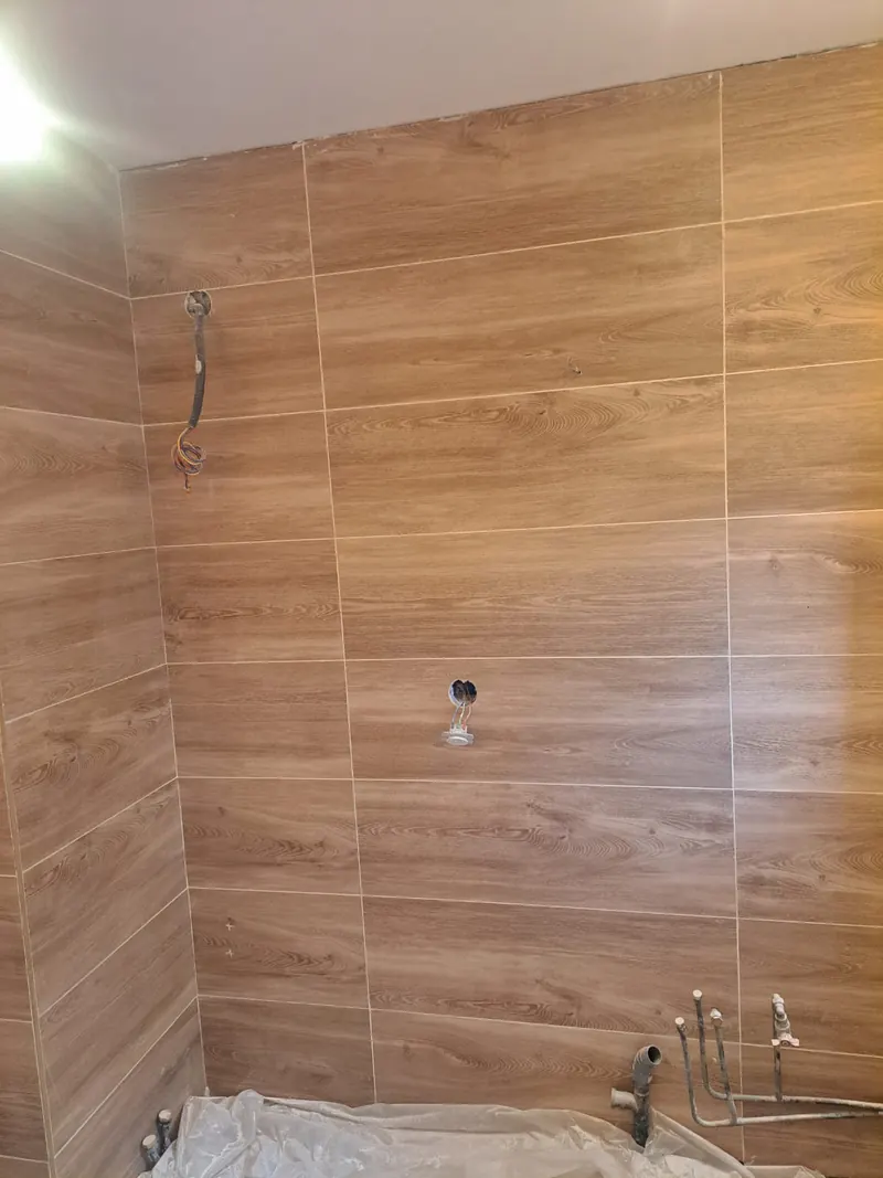 Salle de bain en cours : faïence effet bois grand format posée sur deux murs