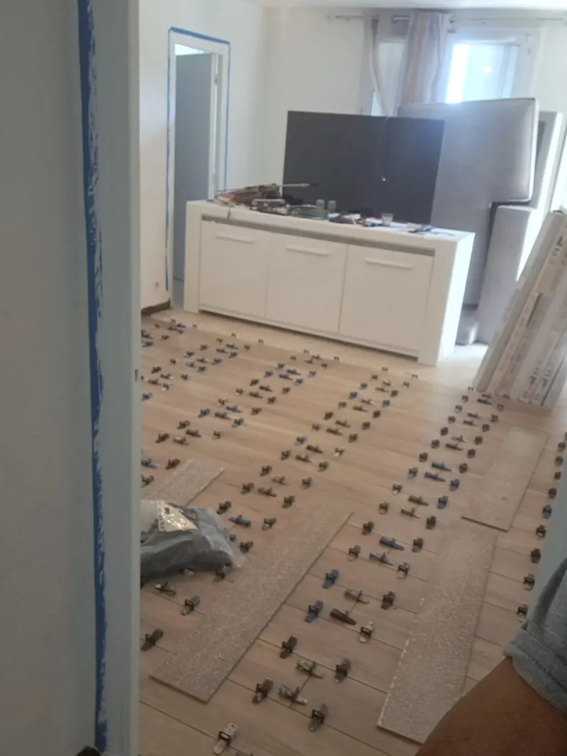Le même séjour pendant la pose du carrelage, avec les cales de nivellement